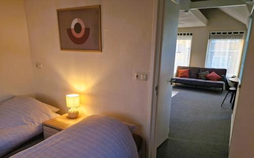 een slaapkamer met 2 bedden en een lamp op een tafel bij Staying-Inn Enschede in Enschede