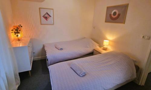 Habitación con 2 camas y mesa con lámpara. en Staying-Inn Enschede en Enschede