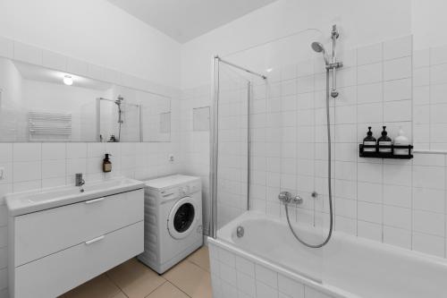 ein weißes Bad mit einer Waschmaschine und einer Dusche in der Unterkunft Beautiful 80sqm Appartment in Berlin-Mitte in Berlin