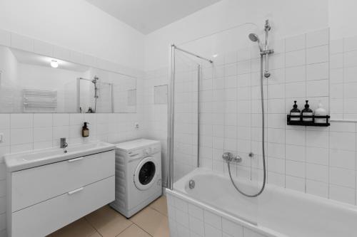 a white bathroom with a washing machine and a shower at Beautiful 80sqm Appartment in Berlin-Mitte in Berlin