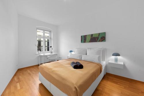 ein weißes Schlafzimmer mit einem großen Bett und einem Fenster in der Unterkunft Beautiful 80sqm Appartment in Berlin-Mitte in Berlin