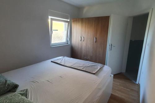a bedroom with a large white bed with a window at Apartment Divine Metković72m2 in Metković