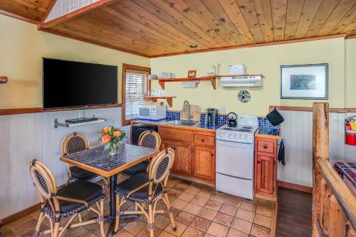 a kitchen with a table with chairs and a television at Cannon Beach Hotel Collection in Cannon Beach