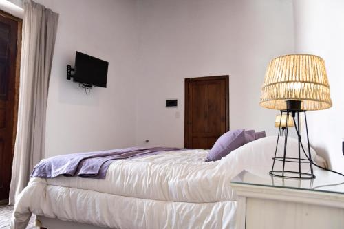 a bedroom with a bed and a table with a lamp at Hostería La Celestina in Tilcara
