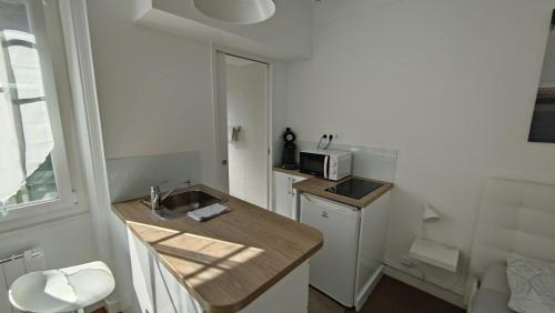 une petite cuisine avec un évier et un micro-ondes dans l'établissement Studio proche de la mer, à La Baule