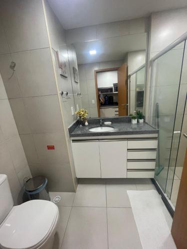 a bathroom with a toilet and a sink and a mirror at Vizinho à igrejinha - Apartamento completo no ECO RESORT Praia dos Carneiros in Praia dos Carneiros