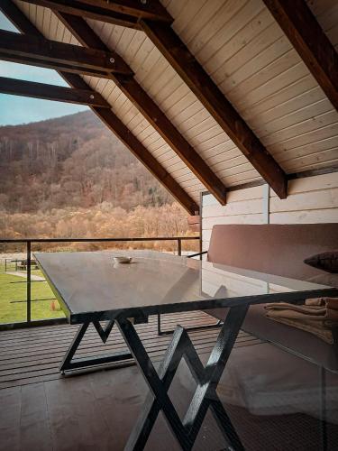 a table and a bench on a balcony with a view at Villa Opir in Skole