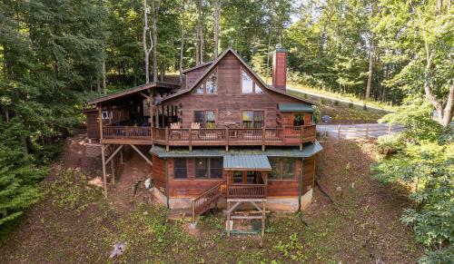 a large wooden house in the middle of a forest at stayNantahala - Smoky Mountain Cabins in Aquone