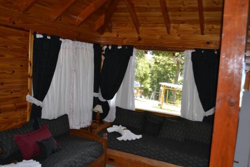 a living room with a couch and a window at Cabañas Akermann in Villa La Angostura