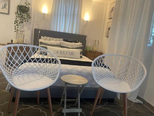 a bedroom with two white chairs and a bed at calvache city in Centro Calvache