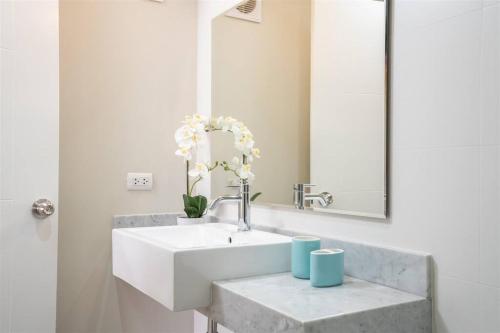 利馬的住宿－Elegant&Modern Apt in San Isidro，浴室设有白色水槽和镜子