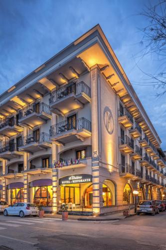a large building with cars parked in front of it at Hotel Il Mulino in Capo dʼOrlando