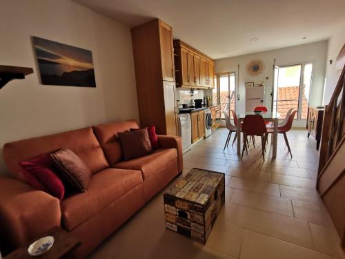 een woonkamer met een bruine bank en een tafel bij Casa na onda Liberdade in Nazaré