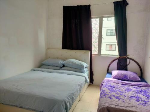 two beds in a small room with a window at Muslim Boutique Apartment with Balcony in Tanah Rata