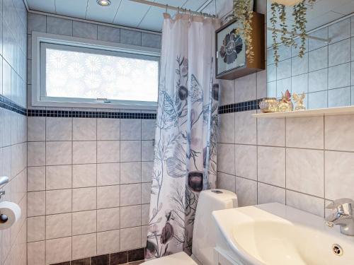 ein Bad mit einem Waschbecken und einem Duschvorhang in der Unterkunft Holiday home Skibby XIII in Skibby