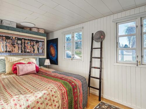 Schlafzimmer mit einem Bett, einer Leiter und Fenstern in der Unterkunft Holiday home Skibby XIII in Skibby