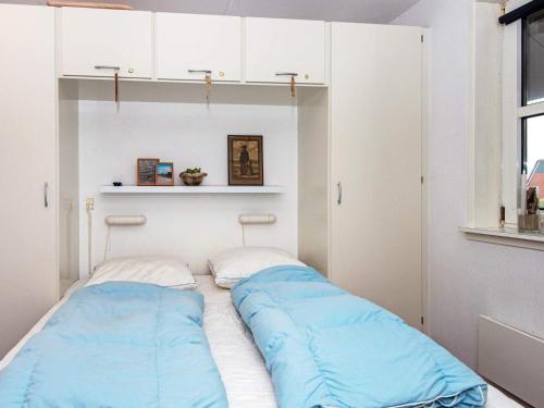 uma cama com duas almofadas azuis num quarto em Holiday Home Golfvejen VII em Fanø