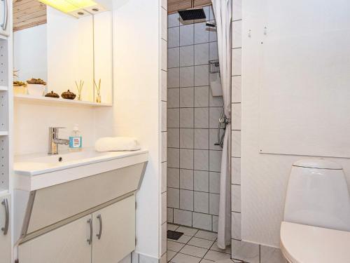 uma casa de banho com um lavatório e um chuveiro em Holiday Home Golfvejen VII em Fanø