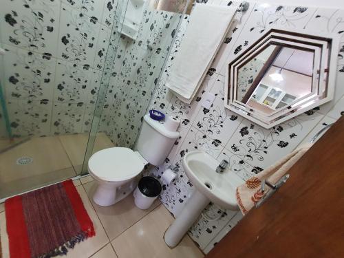 y baño con aseo, lavabo y espejo. en Casa da cachoeira - Ilhabela, en Ilhabela