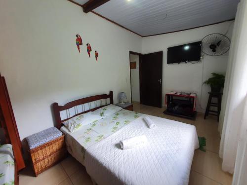 1 dormitorio con 1 cama y TV de pantalla plana en Casa da cachoeira - Ilhabela, en Ilhabela