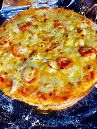 a cheese pizza sitting on top of a table at YOISAMA Sunset Beach House in Ishigaki Island