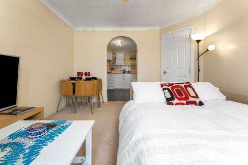 a bedroom with a large bed and a kitchen at Modern 1BR flat - free parking + lift in Edinburgh