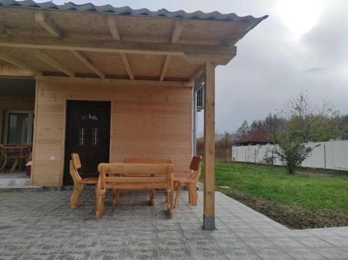 a wooden picnic table and chairs under a pavilion at Homoljski Raj Banja Zdrelo in Ždrelo