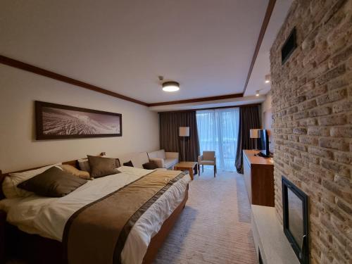 a hotel room with a bed and a brick wall at Apartman Lukas privatni app u sklopu aparthotela Vučko in Jahorina