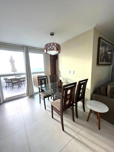 a living room with a couch and a table and chairs at Cobertura Luxo com Jacuzzi Orla Praia Grande in Arraial do Cabo