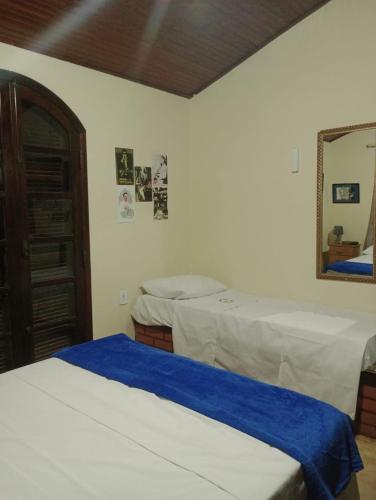 a bedroom with two beds and a mirror at RESONAMUH - Hostel in São Pedro da Aldeia