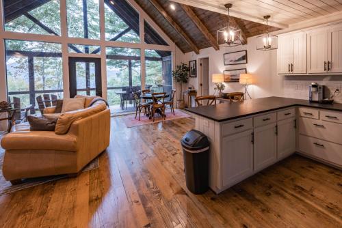 a kitchen and living room with a couch and a table at stayNantahala - Smoky Mountain Cabins in Aquone