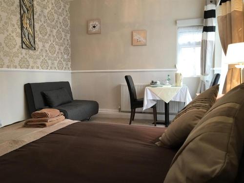 ヨークにあるBurton Villa Guest Houseのベッドルーム1室(ベッド1台、テーブル、椅子付)