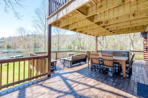 a wooden deck with a table and chairs on it at stayNantahala - Smoky Mountain Cabins in Aquone