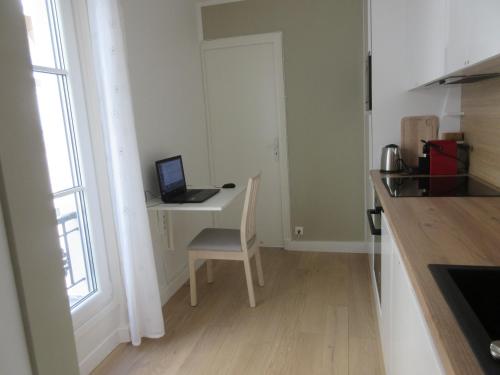 a kitchen with a desk with a laptop computer on it at Bourg-la-Reine : joli appartement de 20 m² in Bourg-la-Reine