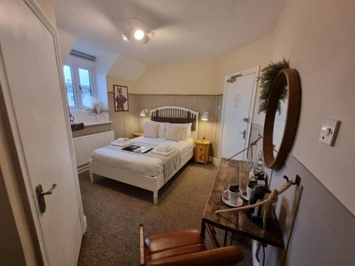 a bedroom with a bed and a mirror and a table at Creates in Monmouth