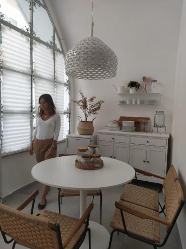 a woman standing in a kitchen with a table and chairs at Nova Rua in Amalfi