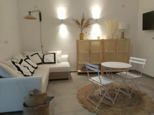 - un salon avec un canapé, une table et des chaises dans l'établissement Nova Rua, à Amalfi