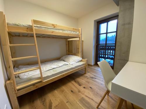 a room with bunk beds and a table and a desk at Wellness apartmán Pila Kvilda in Kvilda