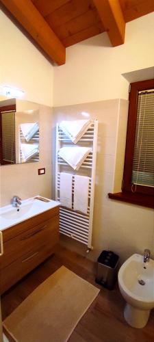 Un baño con lavabo, inodoro y ventana. en Al Posto Giusto, en Nimis