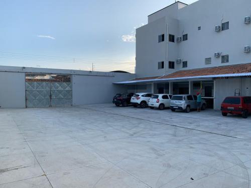 a parking lot in front of a building with parked cars at Hotel Estrela in Castanhal