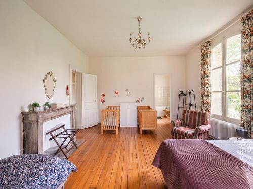 1 dormitorio con chimenea, 1 cama y 1 silla en Majestic villa in Pouru Saint Remy with garden, 