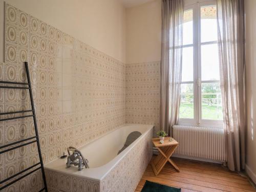 uma banheira na casa de banho com uma janela em Majestic villa in Pouru Saint Remy with garden 