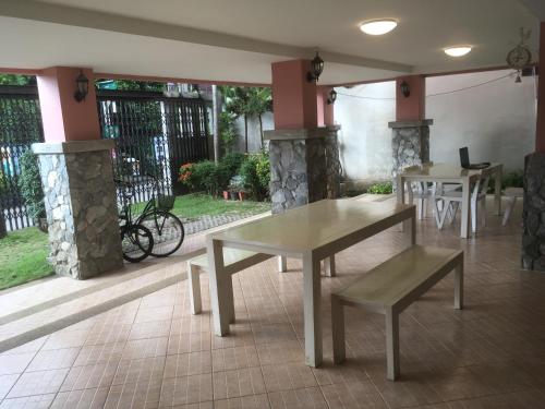 two tables and benches in a room with a patio at Triple Palms House in Chiang Mai