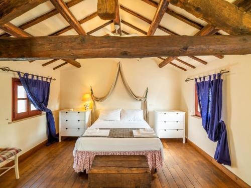 - une chambre avec un lit doté de rideaux bleus et de parquet dans l'établissement Amazing villa in Osimo with private garden, à Osimo