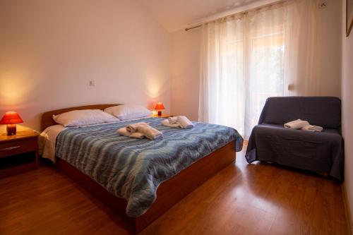 ein Schlafzimmer mit einem Bett mit zwei darauf liegenden Hunden in der Unterkunft Apartment Pasman 8274a in Pašman