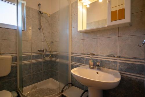 a bathroom with a sink and a shower and a toilet at Apartment Pasman 8274a in Pašman