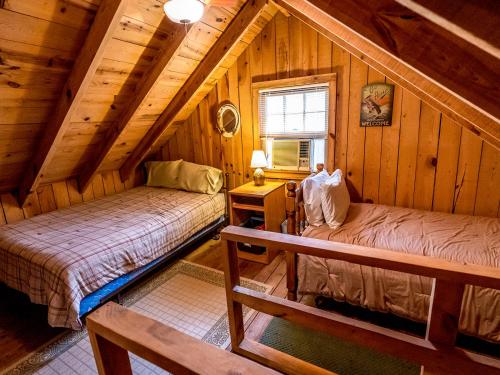 a bedroom with two beds in a log cabin at stayNantahala - Smoky Mountain Cabins in Aquone