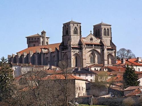 a large church sitting on top of a city at Gîte familial au calme avec jeux, VTT, randonnée, près du Parc Livradois, La Chaise-Dieu et Craponne - FR-1-582-214 in Jullianges
