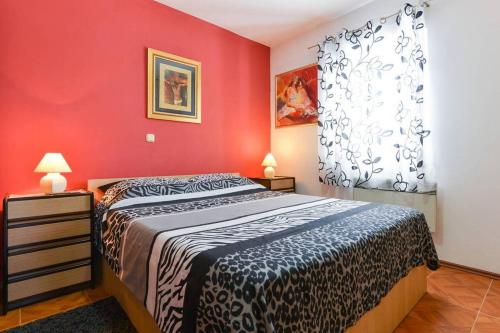 ein Schlafzimmer mit einem Bett und einer roten Wand in der Unterkunft Apartments with a parking space Vrsi - Mulo, Zadar - 13067 in Vrsi