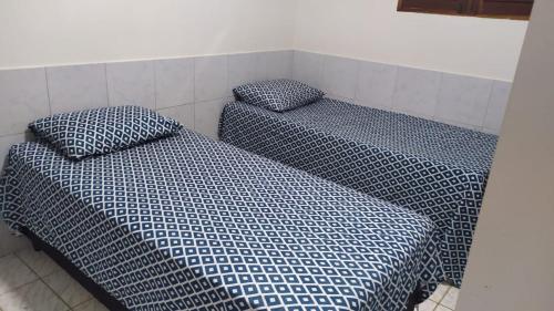 two beds sitting next to each other in a room at Casa com piscina no coração de Lucena in Lucena